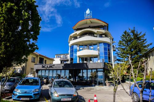 Un edificio con coches aparcados delante. en SU Hotel, en Ohrid