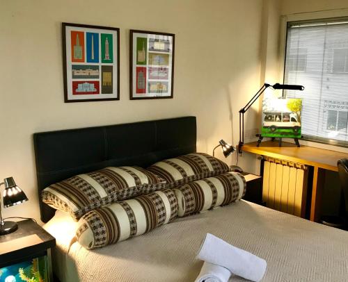 a bedroom with a bed with pillows on it at Departamento en Av Corrientes con estacionamiento para autos menores a 2000 kilos in Buenos Aires