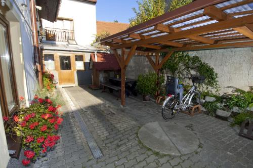a bike parked under a wooden pergola next to a building at Penzion U Třeboňského kola in Třeboň