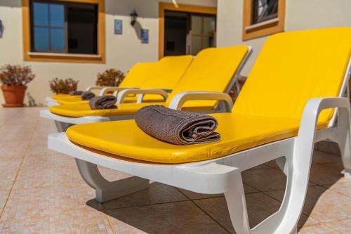 a row of yellow chairs in a waiting room at Casa dos Ninos in São Bartolomeu de Messines