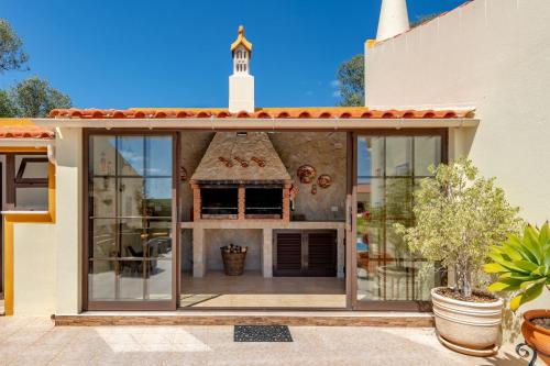 a house with large glass windows and a tower at Casa dos Ninos in São Bartolomeu de Messines
