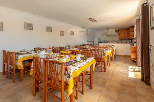 a dining room with yellow tables and chairs at Casa dos Ninos in São Bartolomeu de Messines