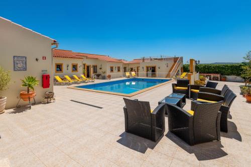 a patio with chairs and a swimming pool at Casa dos Ninos in São Bartolomeu de Messines