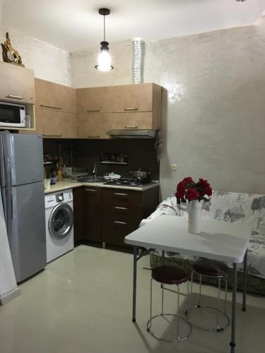a kitchen with a table and a stove and a dishwasher at Апартаменты свидом наморе Гонио in Kvariat'i