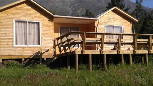 a wooden deck in front of a log cabin at Refugios Olmue Santa Teresa in El Maqui