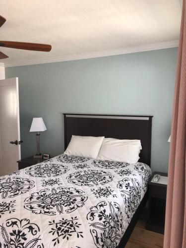 a bedroom with a bed with a black and white comforter at El Rancho Motel in Williams