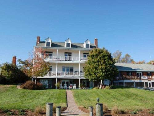 a large house on a hill with a yard at Blue Heron Inn - A Bed and Breakfast LLC in Solomons