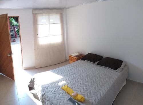 a bedroom with a large white bed with yellow pillows at Posada turística Quenari Wii in Mitú