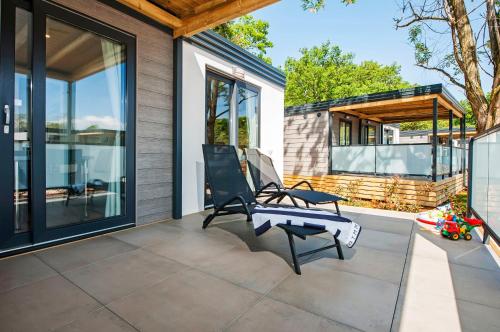 a patio with two chairs and a house at Eurocamp Mobile Homes at FKK Nudist Campsite Solaris in Poreč