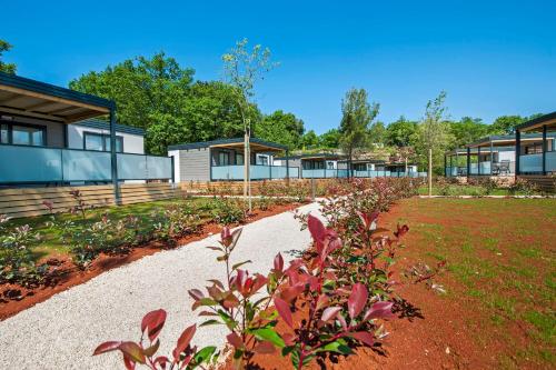 a garden with flowers in front of a building at Eurocamp Mobile Homes at FKK Nudist Campsite Solaris in Poreč