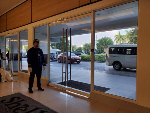 a man standing in front of a revolving door at Shell Residence Manila in Manila