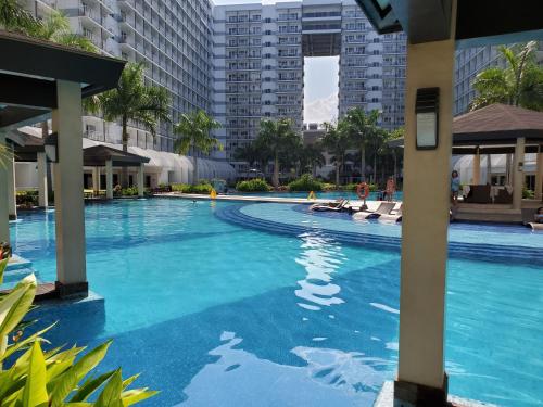 a swimming pool with blue water in a building at Shell Residence Manila in Manila