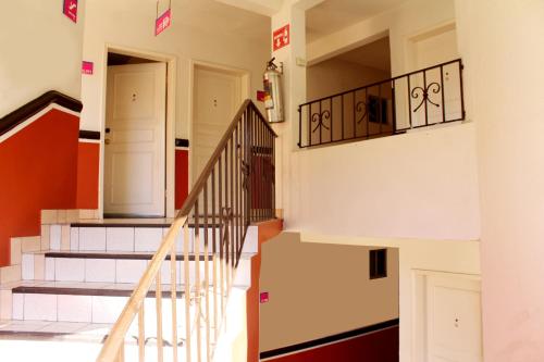 a staircase in a house with white and red walls at Del Mar Inn Playas in Tijuana