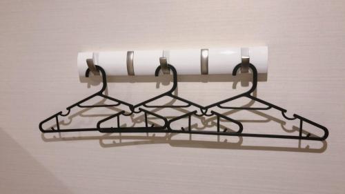 a metal rack with a roll of toilet paper on it at Hotel Abest Grande Okayama in Okayama