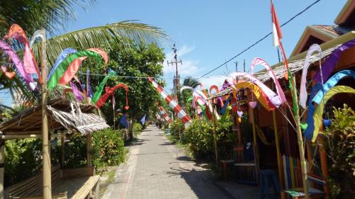 a sidewalk lined with colorful kites and plants at Novita Homestay in Bunaken