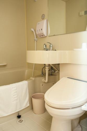 a white bathroom with a toilet and a sink at Toyoko Inn Daegu Dongseongro in Daegu