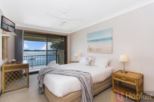 a bedroom with two beds and a balcony at Peninsula Court 6 - LJHooker Yamba in Yamba
