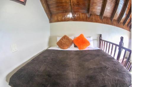 a bedroom with a bed with two orange pillows on it at Shipwatcher Studio w/Mezzanine in Ocho Rios