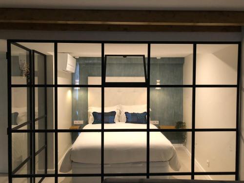 - une chambre avec un lit à travers une fenêtre en verre dans l'établissement Canarios Apartments Catarina, à Lisbonne