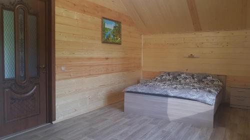 a room with a bed in a log cabin at Гостевой дом с баней in Ostrov