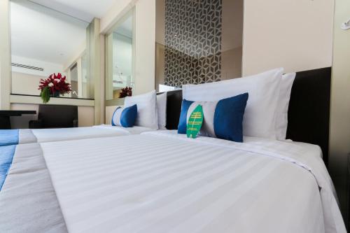 a bedroom with two beds with blue and white pillows at Mandarin Hotel Managed by Centre Point in Bangkok
