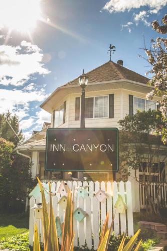 a sign in front of a house with a fence at Inn on Canyon in Radium Hot Springs