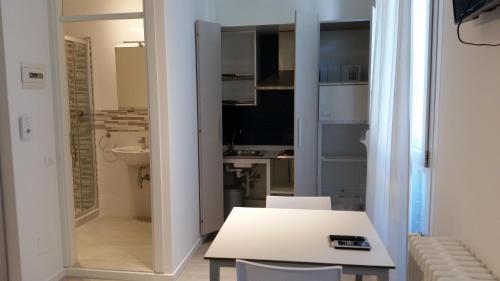 uma cozinha branca com uma mesa e um lavatório em Hotel Stella Polare em Rimini