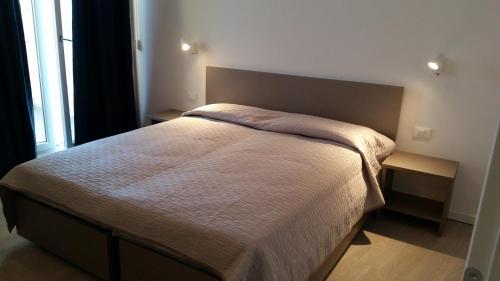 a bedroom with a large bed with a large window at Hotel Stella Polare in Rimini