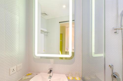 a bathroom with a sink and a mirror at Yello Hotel Jemursari in Surabaya