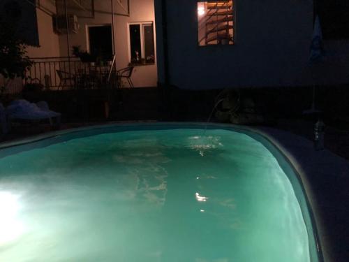 a swimming pool at night with a water fountain at Къща за гости с минерална вода "Терма Асклепий" in Kyustendil