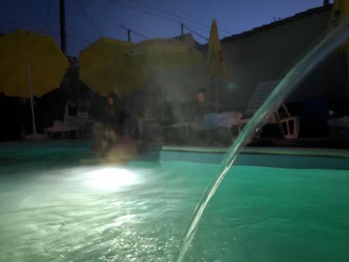 a water fountain in a swimming pool at night at Къща за гости с минерална вода "Терма Асклепий" in Kyustendil