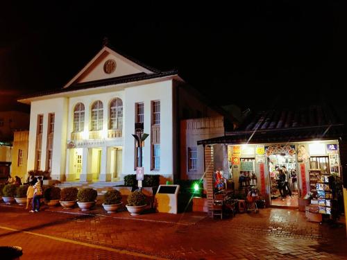 a white building with plants in front of it at night at Youngnn Hostel in Lugang