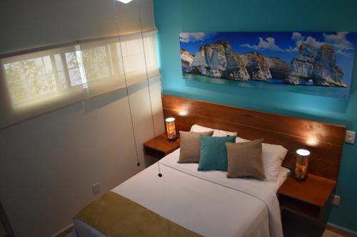 a bedroom with a bed with blue walls at Condo Lux Xareni in Playa del Carmen