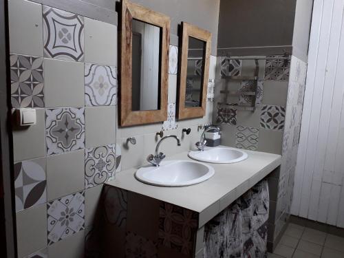 a bathroom with two sinks and two mirrors at Les Pinées in Chateauroux-les-Alpes