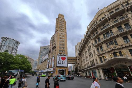 a tall building in the middle of a city at Seventh Heaven Hotel in Shanghai