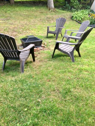 a group of three park benches sitting in the grass at Le Rustique Orford Domaine Cheribourg in Magog-Orford