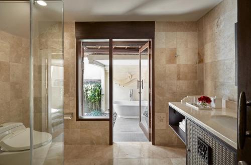 a bathroom with a toilet and a sink and a tub at Kamandalu Ubud in Ubud