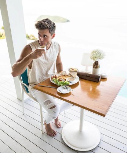 a man sitting at a table looking at his cell phone at Bluerama - Adults Only in Haad Pleayleam