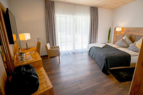 a hotel room with a bed and a large window at Landhotel Lebensart in Xanten
