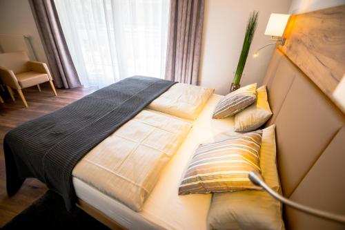 a large bed in a room with a window at Landhotel Lebensart in Xanten