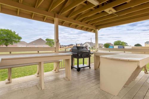 a covered deck with a grill and picnic tables at Comfort Inn & Suites Port Arthur-Port Neches in Port Arthur