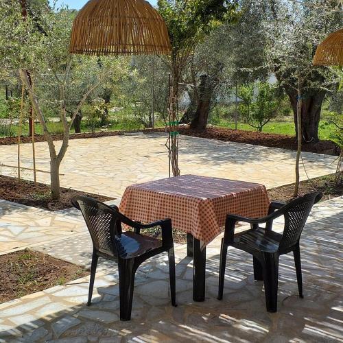 a table with two chairs and a table with an umbrella at Guest House Solive in Himare