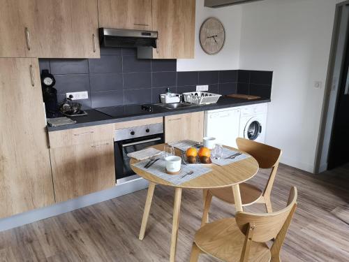 a kitchen with a table and chairs in a kitchen at Hossegor Les Bécasses in Soorts-Hossegor