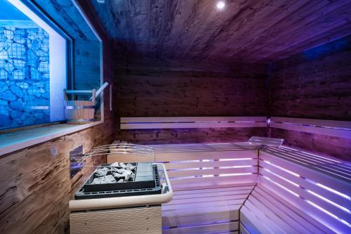 a sauna with a wooden floor and purple walls at Les Dolomites Mountain Lodges in San Martino in Badia