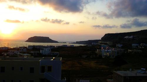 a view of a city with the sun setting over the ocean at Miraluna Aparthotel in Lefkos Karpathou