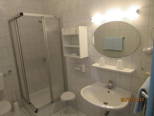 ein Bad mit einer Dusche, einem Waschbecken und einem Spiegel in der Unterkunft Haus Esplanade - Adults only in Reifnitz