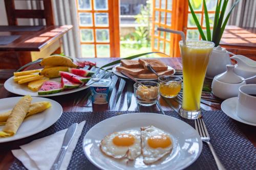 a table with two plates of breakfast food and drinks at Shadow Inn Guest House in Ella