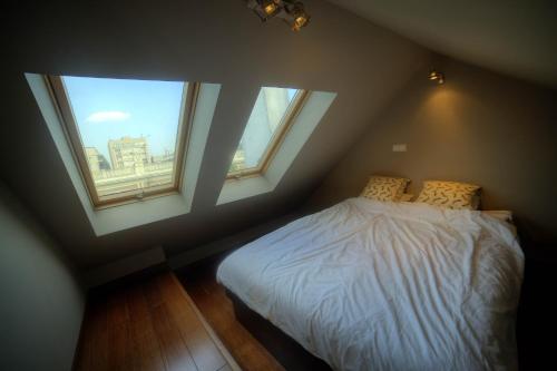 ワルシャワにあるApartament Nowy Światのベッドルーム1室(窓3つ、白いシーツ付きのベッド1台付)