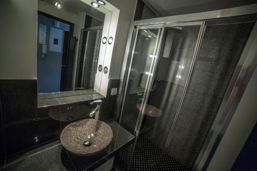 uma casa de banho com um chuveiro, um lavatório e um espelho. em Apartament Nowy Świat em Varsóvia