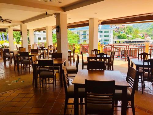 a restaurant with wooden tables and chairs on a patio at Jiraporn Hill Resort in Patong Beach